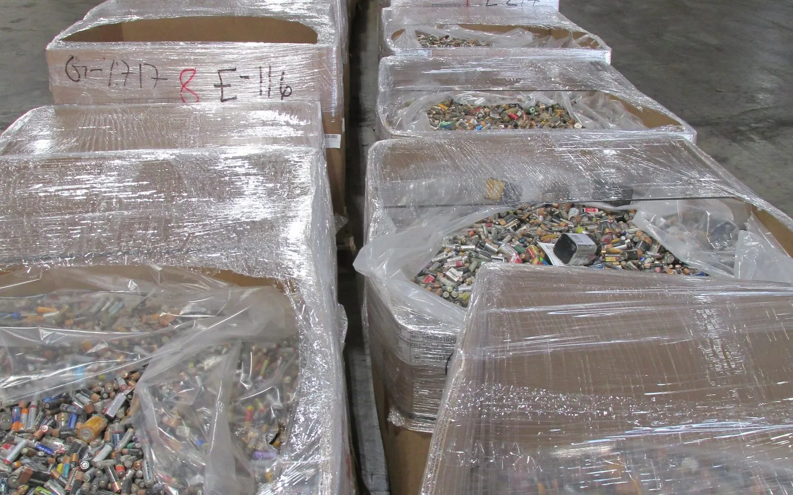 Shrink wrapped pallets of spent alkaline batteries staged for collection