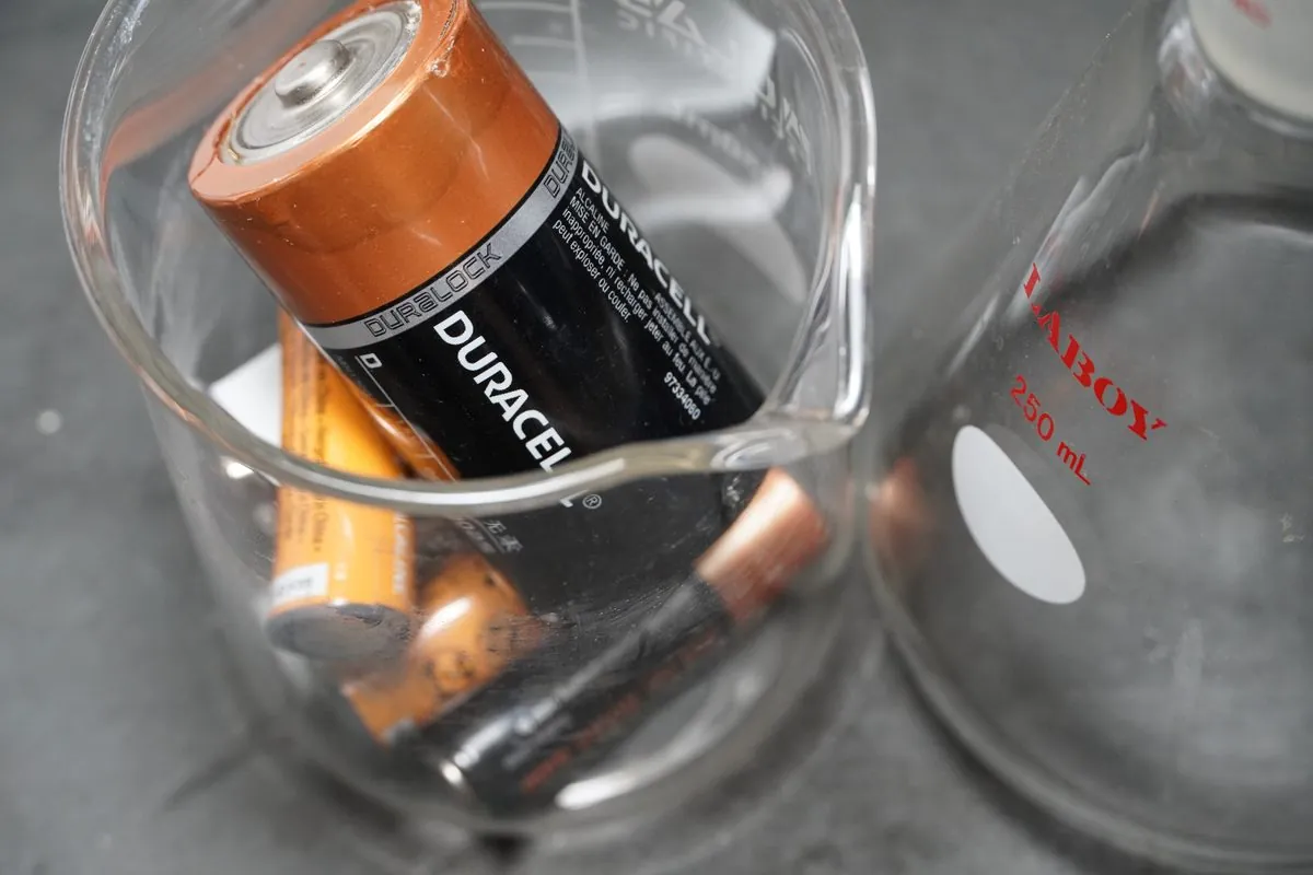 An open corrugated box filled with used alkaline batteries