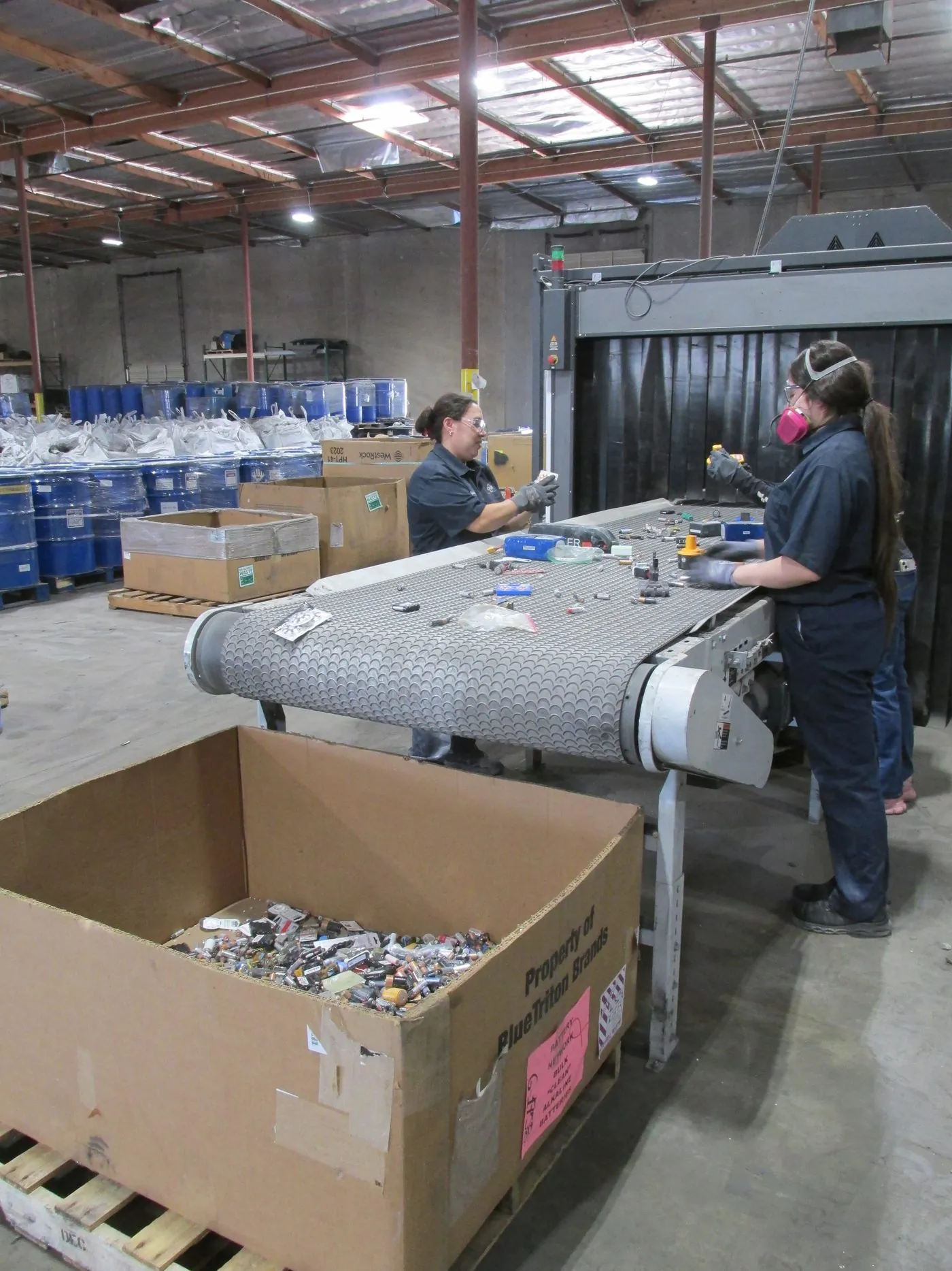 A worker logging an inbound gaylord of spent alkaline batteries at receiving